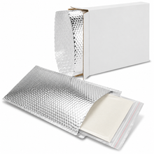 Load image into Gallery viewer, Silver reflective bubble mailer envelopes shown partially opened, with a stack of off-white sheets inside and a plain white box behind them on a clean white background.
